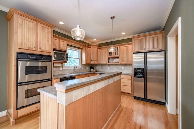 kitchen featuring tasteful backsplash, a center island, sink, hanging light fixtures, and appliances with stainless steel finishes