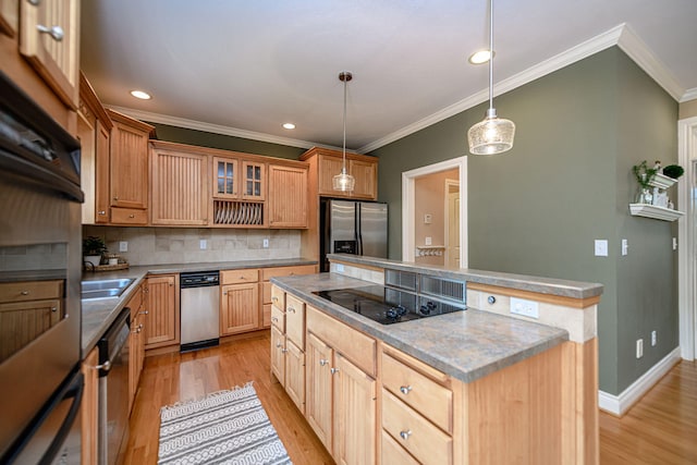 kitchen featuring decorative light fixtures, crown molding, black appliances, and a center island