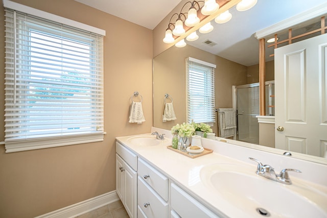 bathroom featuring a wealth of natural light, a shower with door, vanity, and tile patterned flooring