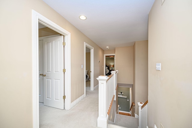 hallway with light colored carpet