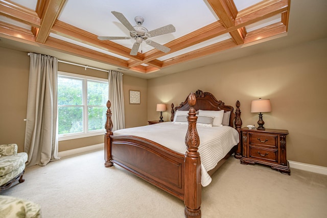 bedroom featuring ceiling fan, beamed ceiling, coffered ceiling, ornamental molding, and light carpet