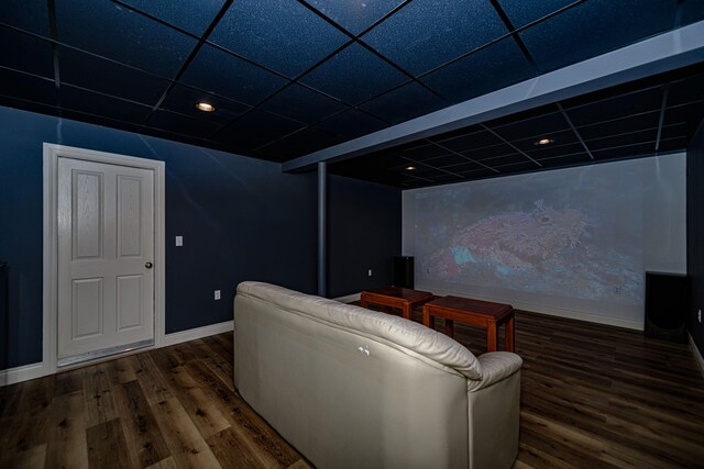 cinema room featuring a paneled ceiling and dark hardwood / wood-style floors