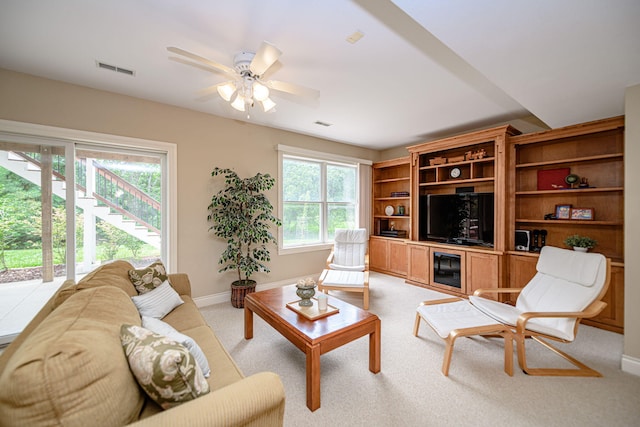 carpeted living room with ceiling fan