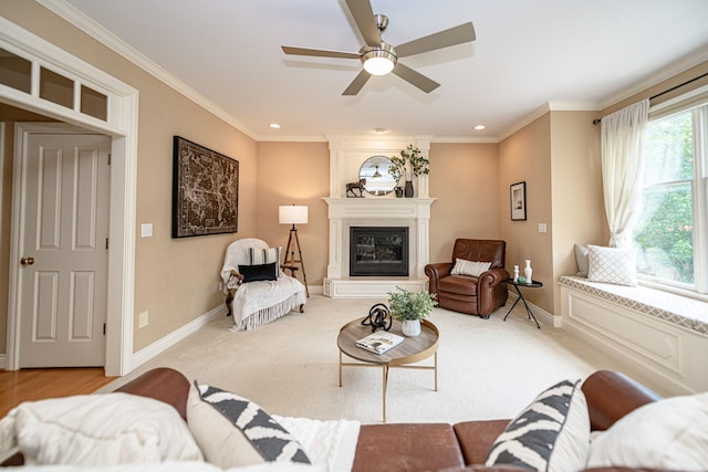 carpeted living room with ceiling fan, crown molding, and a fireplace