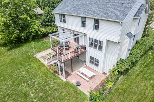 back of property featuring a deck, an outdoor fire pit, a yard, and a patio