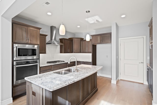1703 Linkside Dr, Columbia, MO 65201 - kitchen featuring stainless steel appliances, wall chimney exhaust hood, a sink, tasteful backsplash, and light wood-style flooring