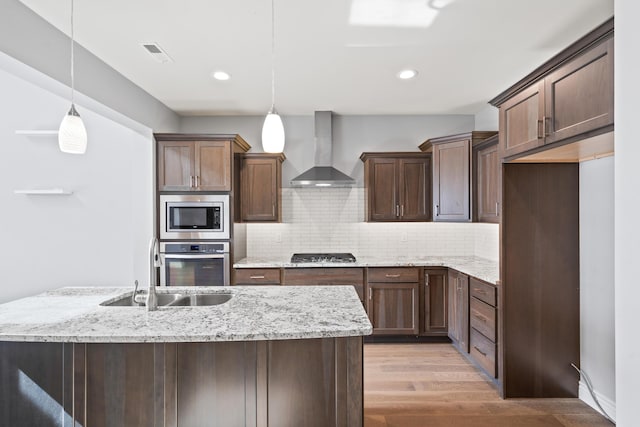 1703 Linkside Dr, Columbia, MO 65201 - kitchen with wall chimney exhaust hood, stainless steel appliances, light wood-style floors, tasteful backsplash, and recessed lighting