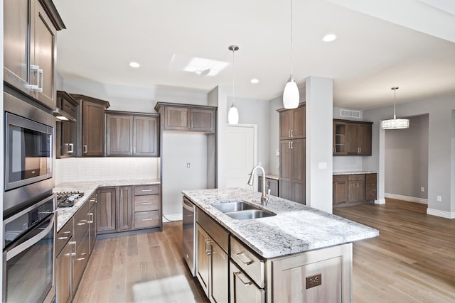 1703 Linkside Dr, Columbia, MO 65201 - kitchen with appliances with stainless steel finishes, a sink, light wood-type flooring, baseboards, and a kitchen island with sink