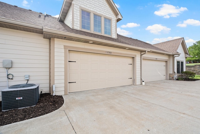 1703 Linkside Dr, Columbia, MO 65201 - view of side of property with central AC unit, concrete driveway, and roof with shingles