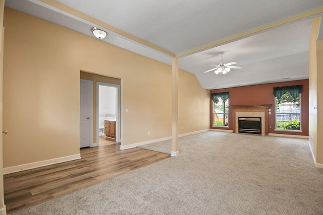 604 Adens Woods Ct, Columbia, MO 65201 - unfurnished living room featuring carpet, a ceiling fan, vaulted ceiling, and a glass covered fireplace