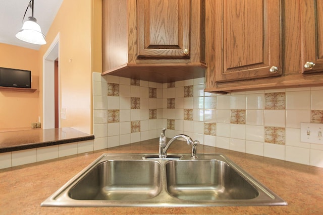 604 Adens Woods Ct, Columbia, MO 65201 - kitchen with brown cabinetry, backsplash, and hanging light fixtures