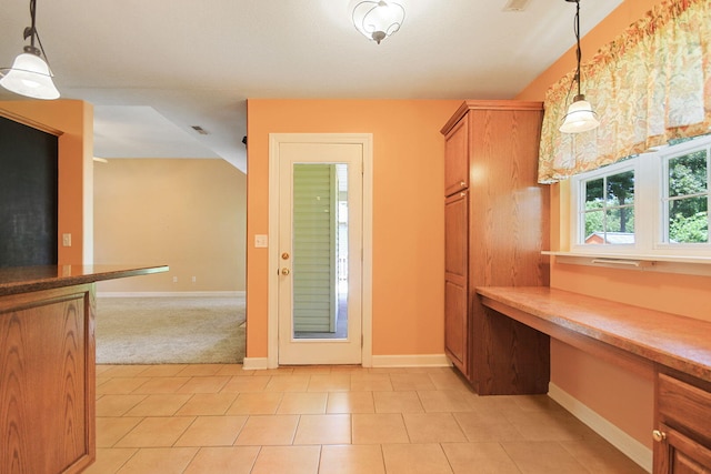 604 Adens Woods Ct, Columbia, MO 65201 - kitchen with built in desk, brown cabinets, pendant lighting, and light carpet