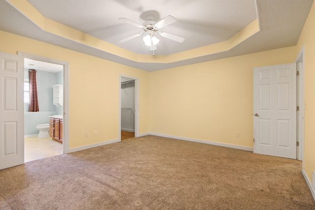 604 Adens Woods Ct, Columbia, MO 65201 - unfurnished bedroom featuring light carpet, a raised ceiling, a walk in closet, connected bathroom, and a closet
