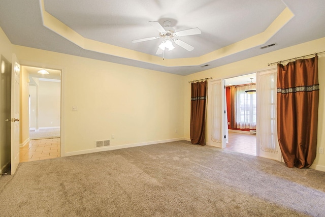 604 Adens Woods Ct, Columbia, MO 65201 - unfurnished bedroom featuring a raised ceiling, carpet floors, a ceiling fan, and tile patterned flooring