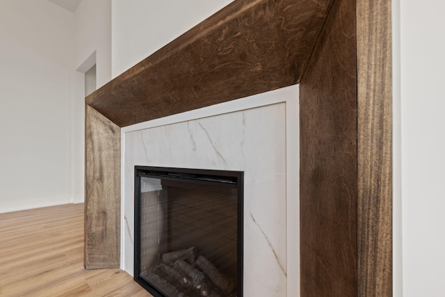 interior details with a high end fireplace and hardwood / wood-style flooring