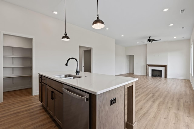 kitchen with pendant lighting, dishwasher, light hardwood / wood-style flooring, and sink