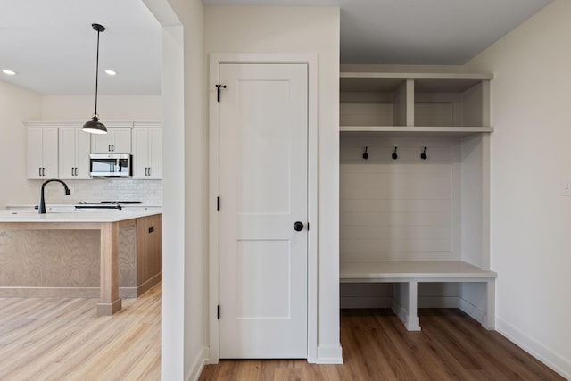 mudroom with light wood-type flooring and sink