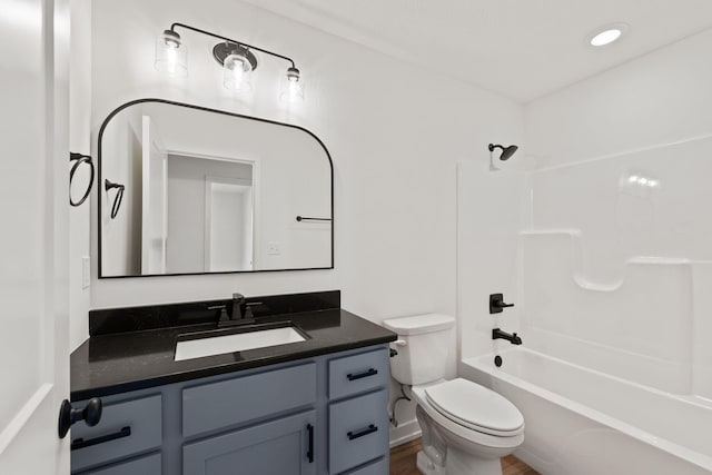 full bathroom featuring hardwood / wood-style flooring, shower / bathtub combination, toilet, and vanity