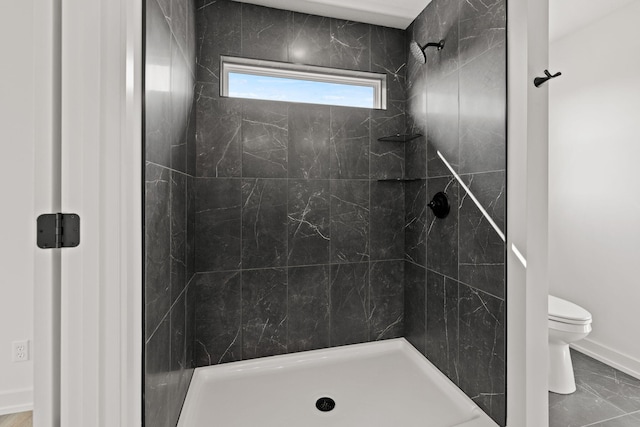 bathroom featuring toilet and tiled shower