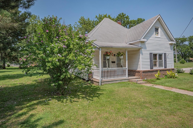 view of front of house featuring covered porch and a front lawn