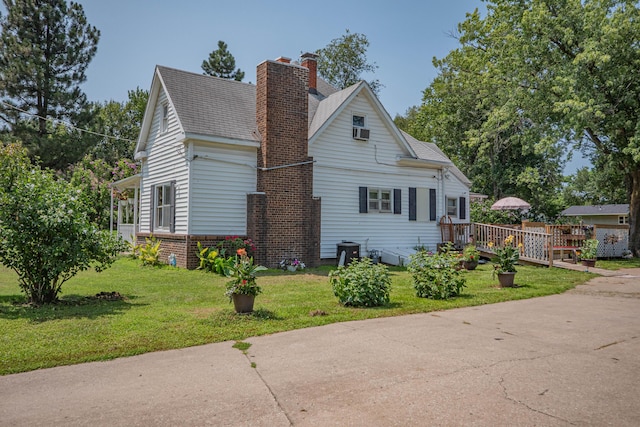 view of side of home featuring a lawn and a wooden deck