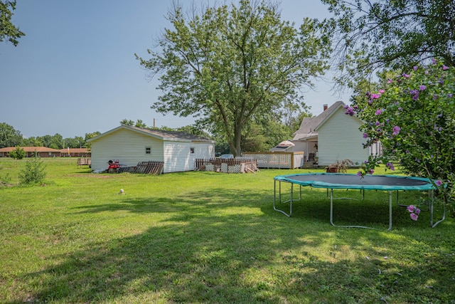 view of yard with a pool and a trampoline