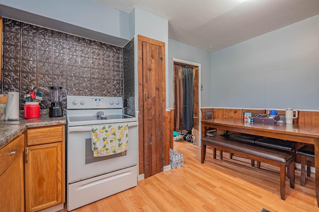 kitchen with white electric range and light hardwood / wood-style flooring