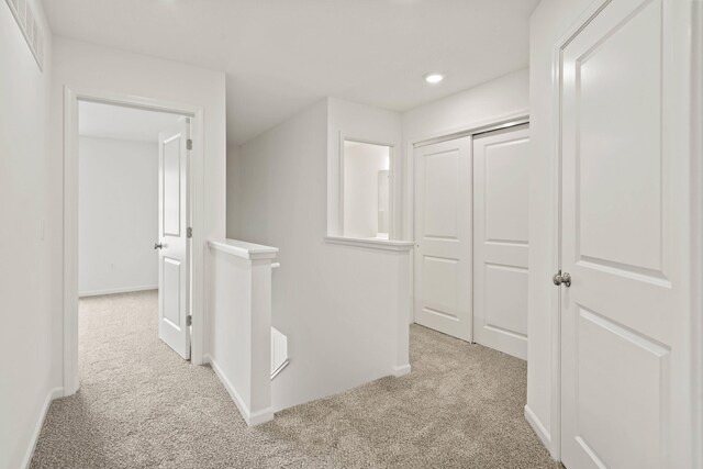 hallway with light colored carpet