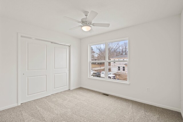 unfurnished bedroom featuring ceiling fan, a closet, and carpet floors