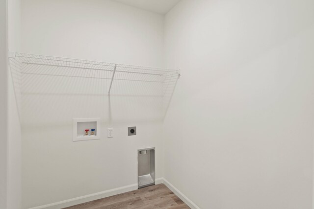 clothes washing area featuring washer hookup, light hardwood / wood-style flooring, and electric dryer hookup