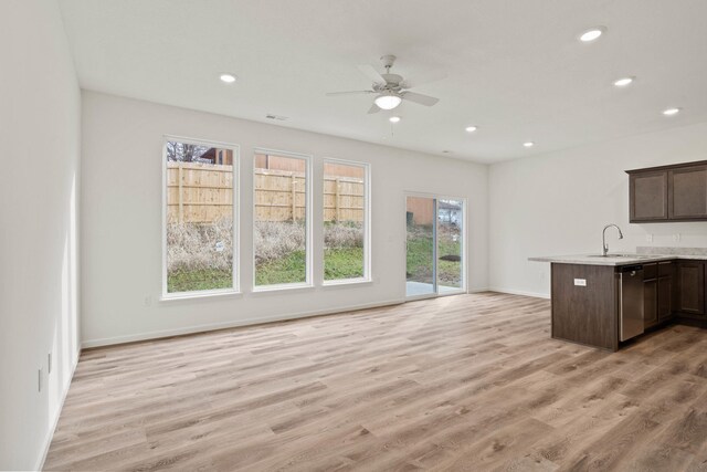 kitchen featuring kitchen peninsula, light hardwood / wood-style flooring, stainless steel dishwasher, and sink