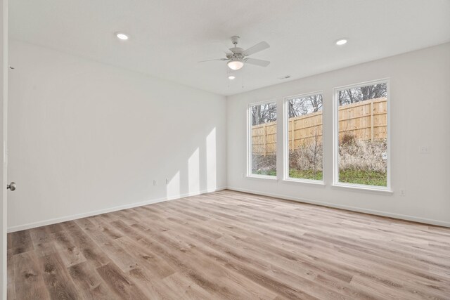 spare room with light wood-type flooring and ceiling fan