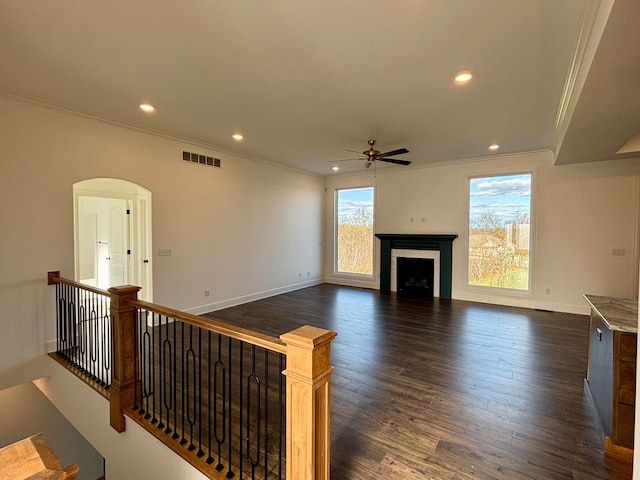 unfurnished living room featuring recessed lighting, a fireplace, visible vents, ornamental molding, and dark wood-style floors