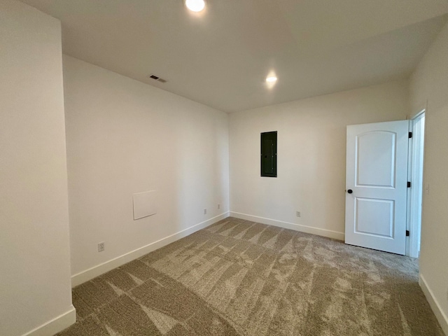 empty room featuring electric panel, visible vents, baseboards, carpet flooring, and recessed lighting