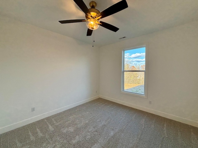 carpeted empty room featuring a ceiling fan, visible vents, and baseboards