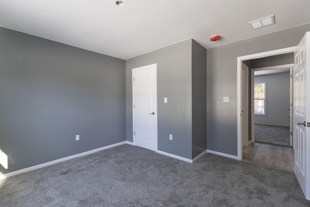 unfurnished bedroom featuring dark colored carpet