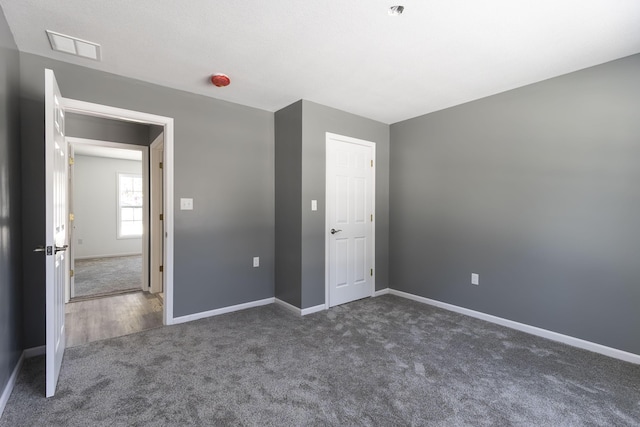 unfurnished bedroom featuring dark carpet