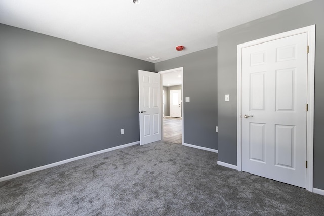 unfurnished bedroom featuring dark colored carpet