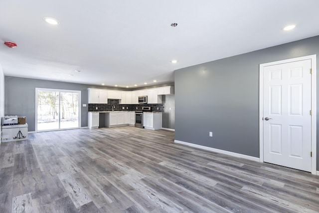 unfurnished living room with sink and hardwood / wood-style flooring