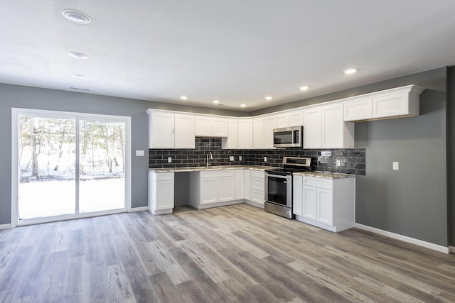 kitchen featuring light hardwood / wood-style flooring, stainless steel appliances, white cabinetry, and sink