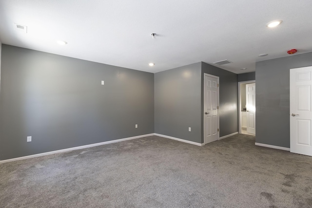 spare room with dark carpet