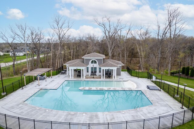 view of pool with an outbuilding, a patio area, and a lawn