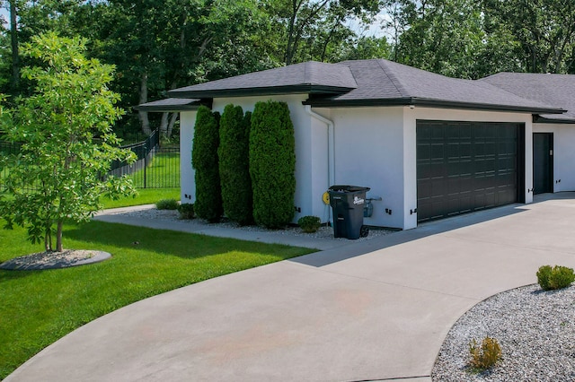 view of home's exterior with a garage and a lawn