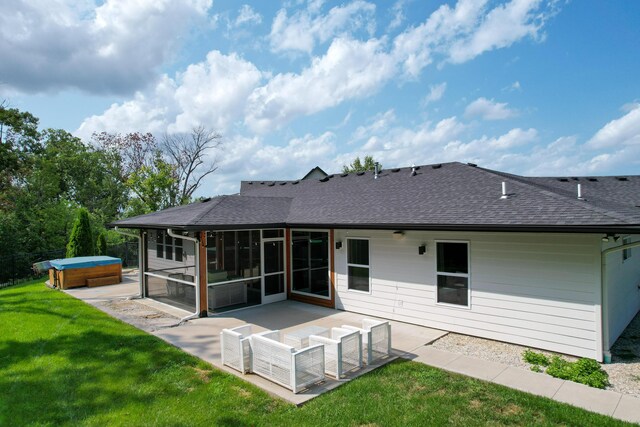 back of property with a hot tub, a sunroom, a patio area, and a yard