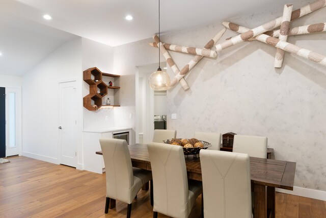 dining room featuring light hardwood / wood-style floors and vaulted ceiling