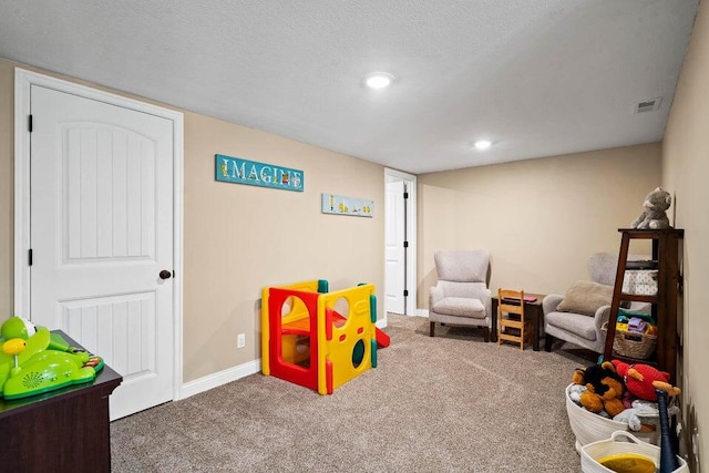 recreation room featuring carpet and a textured ceiling