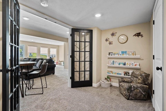 carpeted office with french doors and a textured ceiling