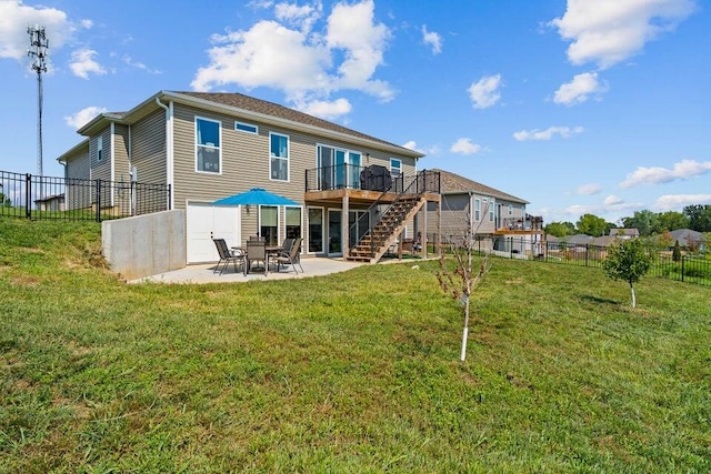 rear view of property featuring a patio area, a lawn, and a wooden deck