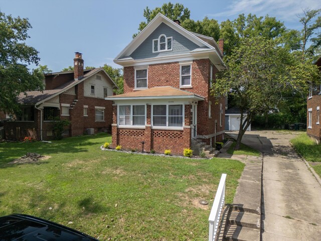 view of front of property featuring concrete driveway, brick siding, a front lawn, and an outdoor structure