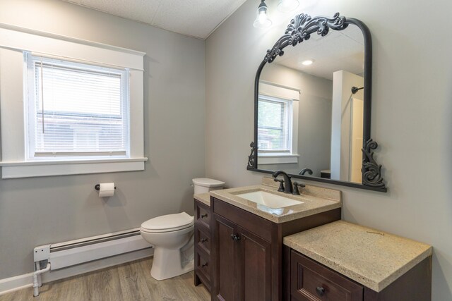 bathroom featuring a baseboard radiator, vanity, toilet, and wood finished floors